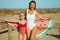 Cheerful modern mother and child holding funny watermelon towel