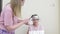 Cheerful mother and daughter dye their hair and do highlighting at home.