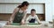 Cheerful mother and happy cute daughter kid baking together