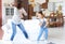 Cheerful mother with little daughter dancing at favourite song in living room at home