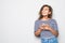 Cheerful mulatto curly woman tuping on the phone isolated on gray background