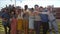 Cheerful multi-ethnic friends standing at rooftop and toasting towards camera