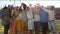 Cheerful multi-ethnic friends standing at rooftop and toasting towards camera