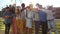 Cheerful multi-ethnic friends standing at rooftop and toasting towards camera