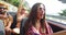 Cheerful multi ethnic students enjoying vacation driving in red convertible