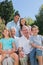 Cheerful multi generation family sitting on a bench in park