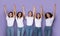 Cheerful Multiethnic Ladies Holding Hands Posing Together Over Purple Background