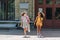 Cheerful multiethnic schoolgirls smiling while running in schoolyard