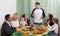 Cheerful multigenerational family sitting at holiday table