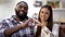Cheerful multiracial couple showing heart sign made with hands at camera, love