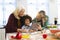 Cheerful multiracial mother and grandmother showing recipe to boy over digital pc in kitchen