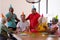 Cheerful multiracial seniors wearing party hats while celebrating friend\'s birthday in nursing home