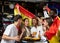 Cheerful multiracial soccer fans waving the flag of Spain while drinking beer in sport bar