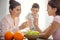 Cheerful mum showing vitamins to her kids