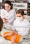 cheerful nail technician offering to female client to choose color of nail polish in beauty salon