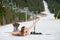 Cheerful naked female skier is having fun on snowy slope near ski lift at ski resort