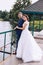 Cheerful newlyweds stand on the pier in an embrace