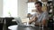 Cheerful office worker at desk doing thumb up sign and smiling. Real workplace