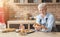 Cheerful old lady posing with freshly baked pastry in kitchen