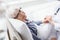 Cheerful old woman situating in cot in hospital