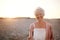 Cheerful old woman standing on the beach