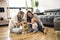 Cheerful parent playing with his baby girl on floor at living room