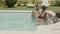 Cheerful parents and kids talking while relaxing in pool