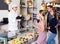 Cheerful pastry chef man is serving visitors