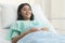 Cheerful patient smiling on the bed in hospital