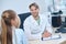 Cheerful pediatric audiologist sitting at the desk during the consultation