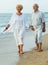 cheerful pensioners walking barefoot together