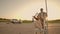 Cheerful people a couple a man and a woman at sunset ride on supermarket trolleys in slow motion