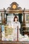Cheerful pharmacist chemist woman standing in trading hall in vintage pharmacy drugstore