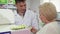 Cheerful pharmacist offering elderly female customer medication in pills