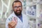 Cheerful pharmacist selling medication at his drugstore