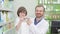 Cheerful pharmacist smiling to the camera with a cute little boy