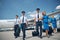 Cheerful pilots and stewardesses carrying travel bags at airport