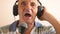 Cheerful playful Caucasian pensioner pooret in headphones with a microphone has fun at home. An elderly man of 70 years old sings