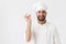 Cheerful pleased young chef posing isolated over white wall background in uniform