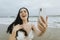 Cheerful plus size woman taking a selfie at the beach