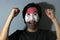 Cheerful portrait of a man with the flag of Yemen painted on his face on grey background. The concept of sport or nationalism.