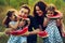 Cheerful positive family of four having a picnic and eating watermelon outdoors in a sunny weather. Curly beautiful twins sisters