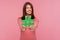 Cheerful positive female blogger in pink sweater holding green hashtag sign in hands, easy blog search, tagging
