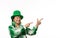 Cheerful positive woman in green carnival wear for St. Patrick's Day, points finger up at copy space on white