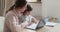 A cheerful preschool boy playing and fooling around with computer, and mother young woman teach him