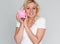 Cheerful pretty woman holding piggy bank