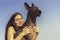 Cheerful pretty young girl sitting and hugging her dog xoloitzcuintli at the blue sky at sunset