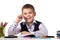 Cheerful pupil sitting at the desk surrounded with stationery