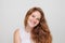 Cheerful real redhead woman with long wavy ginger hairstyle smiling joyfully