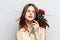 cheerful red-haired woman holding flower rose reborn charm model  background